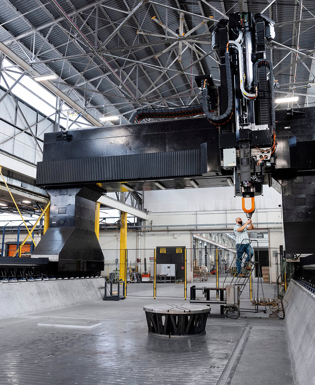 An engineer inspecting a large piece of manufacturing equipment in a warehouse