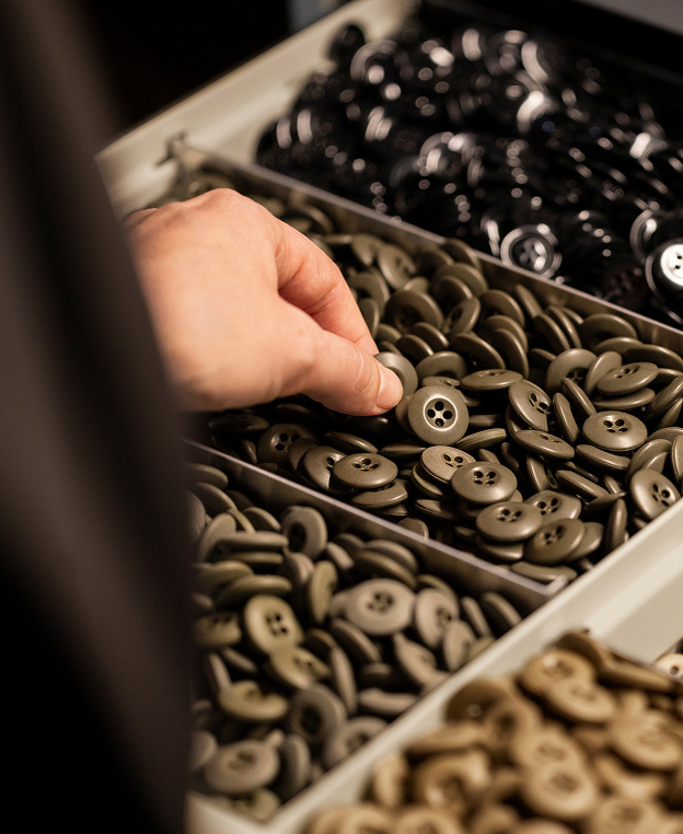 A neatly organized bin containing garment buttons of various colors and sizes