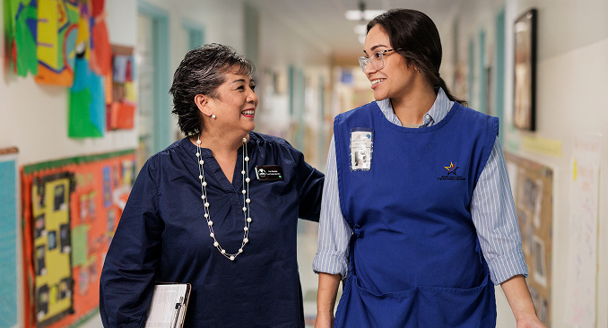 Two female school employees walking in the hall of an elementary school